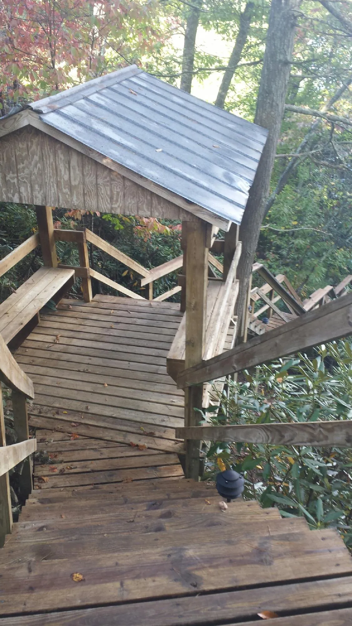 Metal roofed shelter over wooden steps on a wooded walkway — Skylight Repair & Installation work by our crew in Paoli