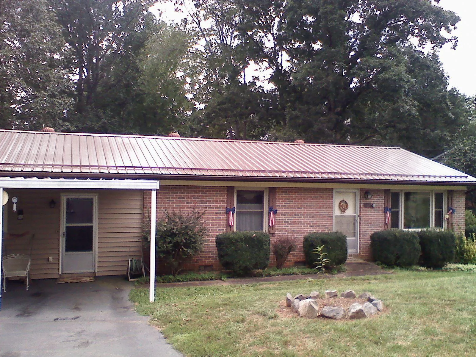 Bronze metal roof and carport on a brick ranch home — Roof Repair work by our crew in Paoli